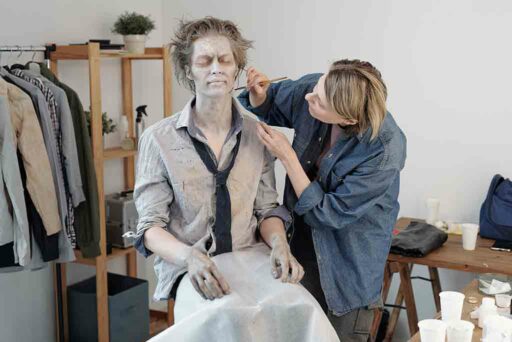The makeup artist applies the appropriate makeup suited for the scene on the actors.